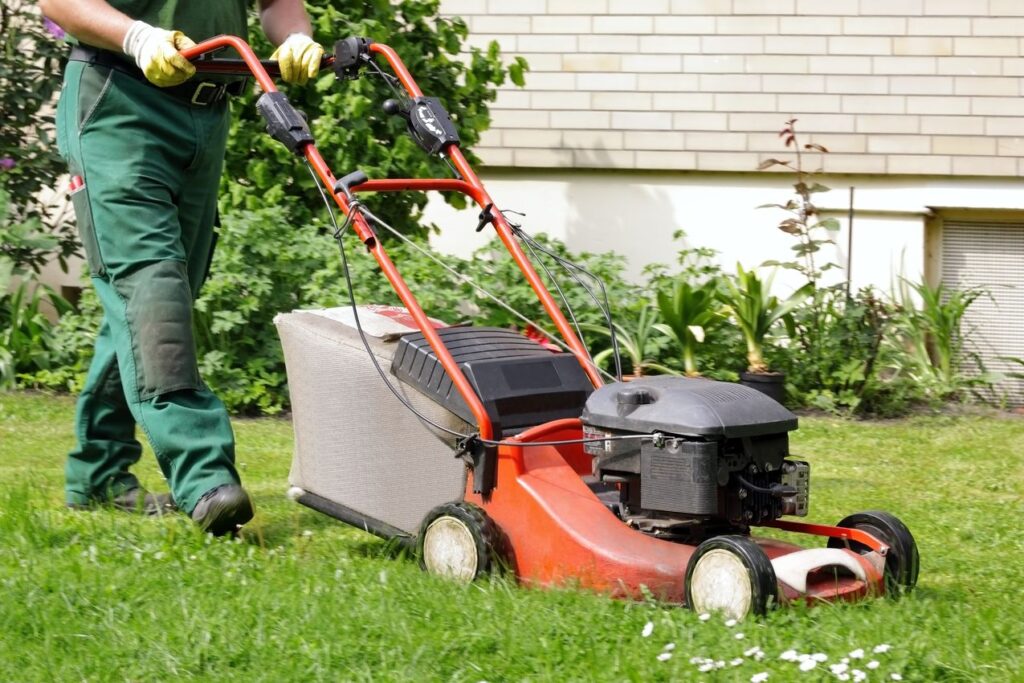 jardinier paysagiste qui tond la pelouse